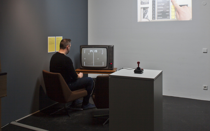 A man sits in front of a TV and plays a video game