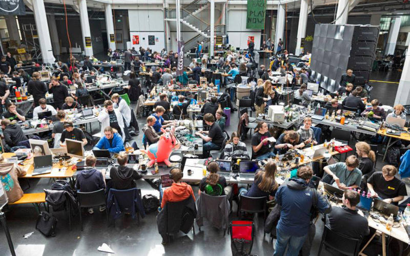 A room full of people who are sitting at desks in front of their computers