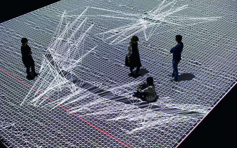 Four People standing on a huge datamatrix