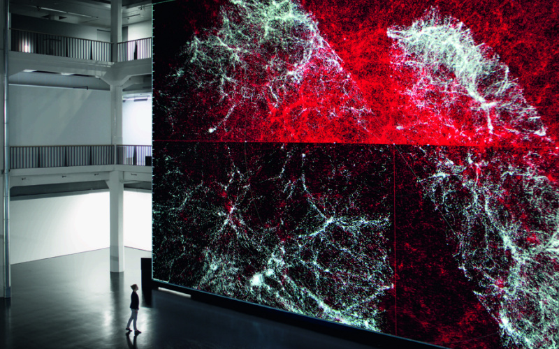 Riesige Leinwand aus roter Datenmatrix, davor ganz klein die Konturen eines Menschen
