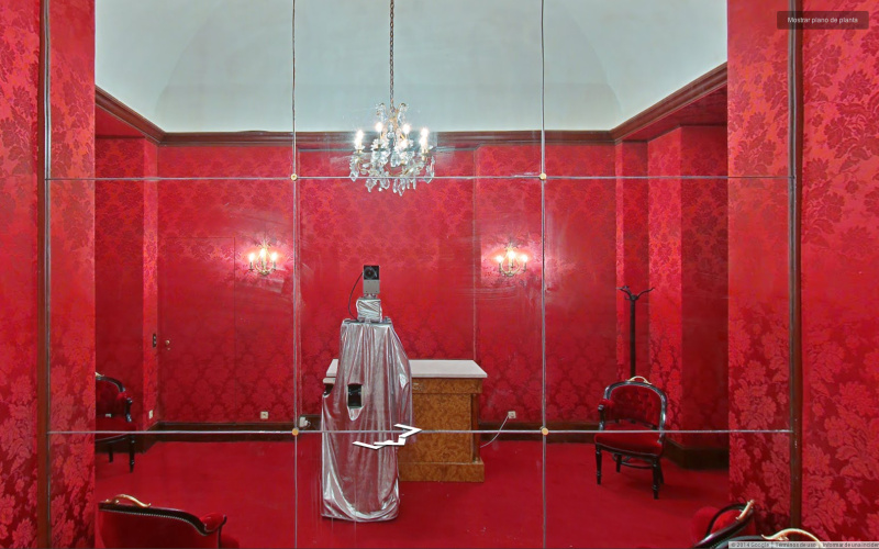 Roter Raum mit Spiegelwand, eine Kamera schießt ein "Selfie"