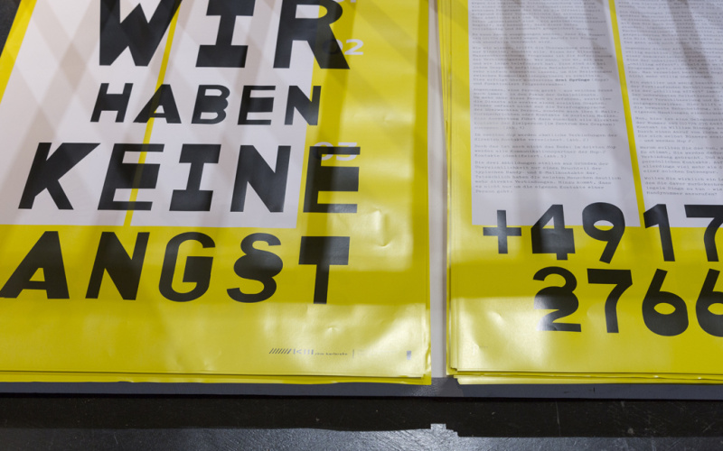Ein gelb-weißes Transparent auf dem steht: "Wir haben keine Angst" und eine Telefonnummer