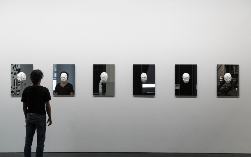 In plaster casted masks hang on mirrors
