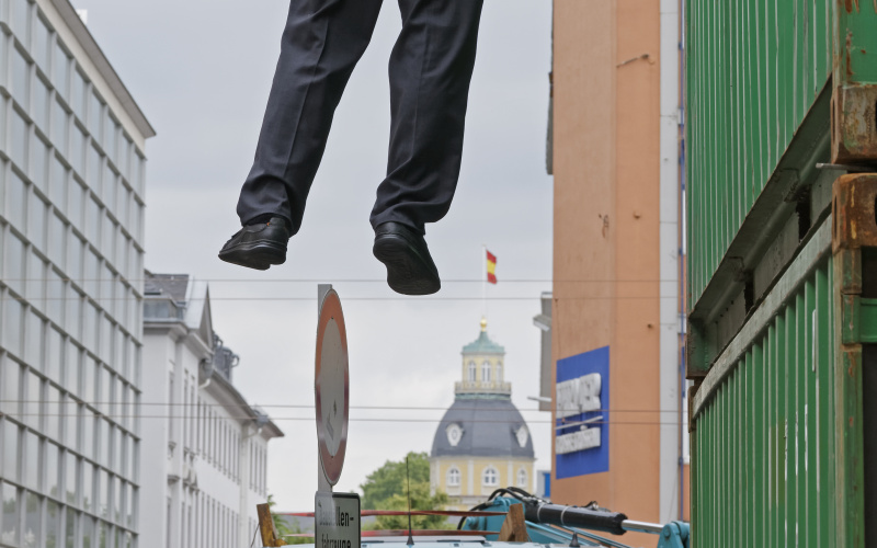 A man hanging in the air, holding himself with one hand.