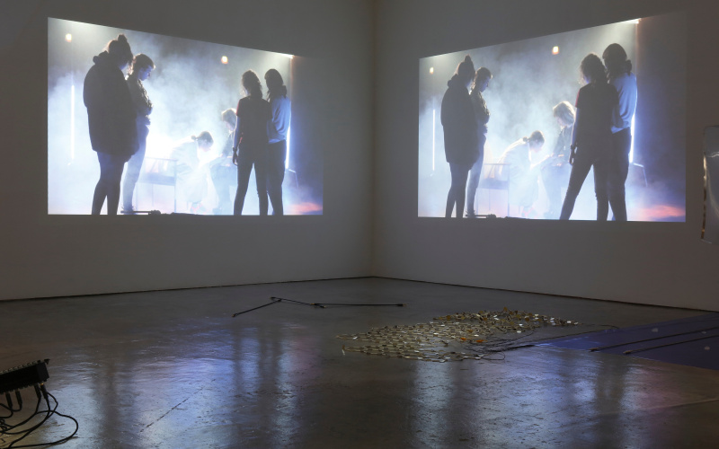 Doppelte Installation mit Menschen in Nebel, projieziert an Wand