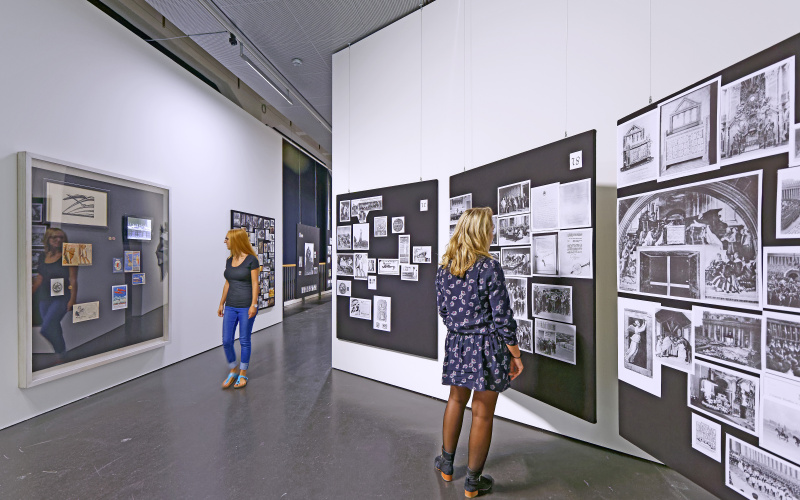 Zwei Frauen schauen sich den Bilderatlas von Aby Warburg an