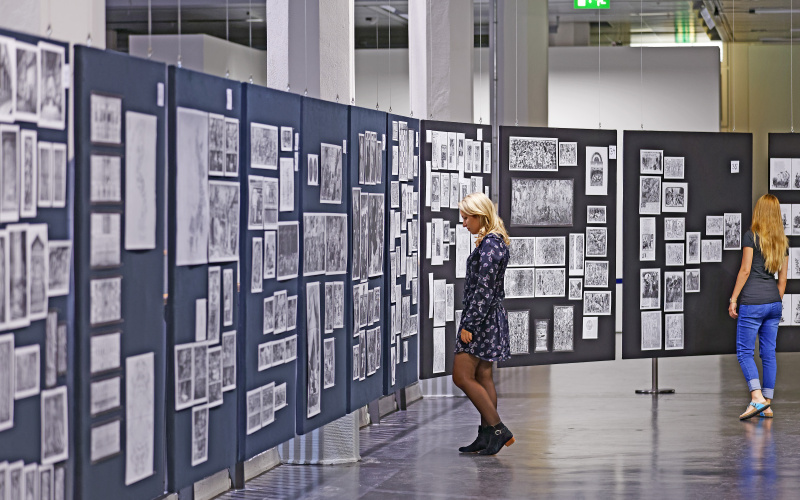 Zwei Frauen schauen sich den Bilderatlas von Aby Warburg an