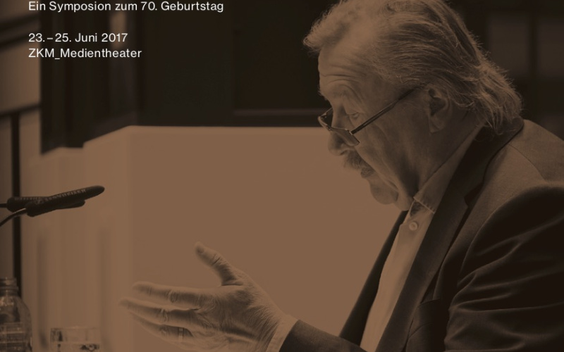 Photo of Peter Sloterdijk during a lecture, sitting at a table.