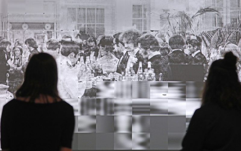  Two visitors before the projection of a photograph of a formal ball evening.