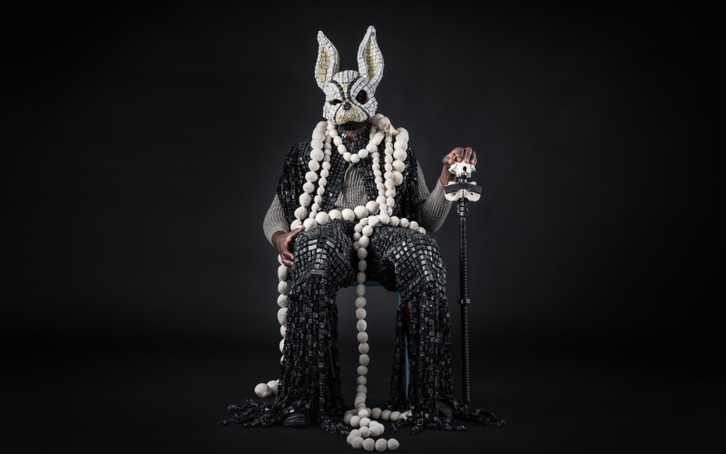 Sitting man with a robe out of keys and a mask