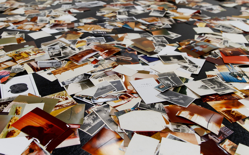 Eine Installation von Dieter Hacker. Auf dem Boden des Ausstellungsraums sind farbige Fotografien verteilt.