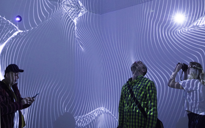 In a room whose walls consist only of mirrors, a light show creates the impression of an infinitely large room.