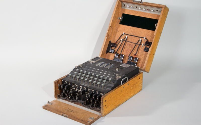 Black apparatus with buttons and cables in a wooden box