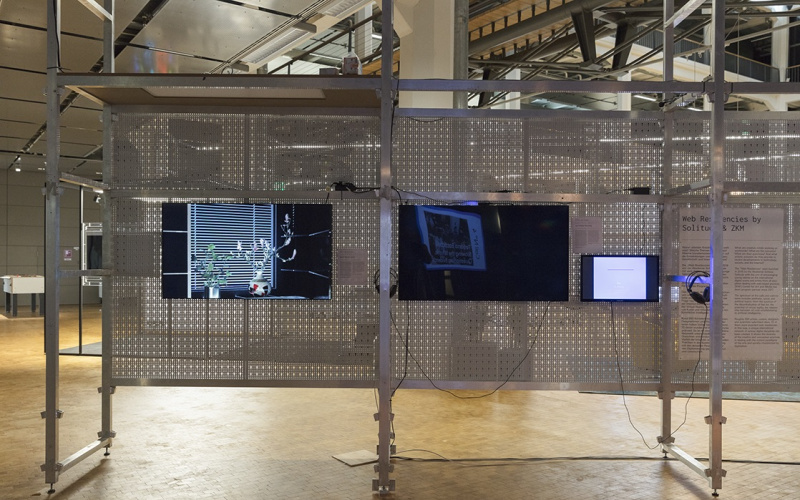 Das Bild zeigt drei Bildschirme an einer Gitterstruktur befestigt