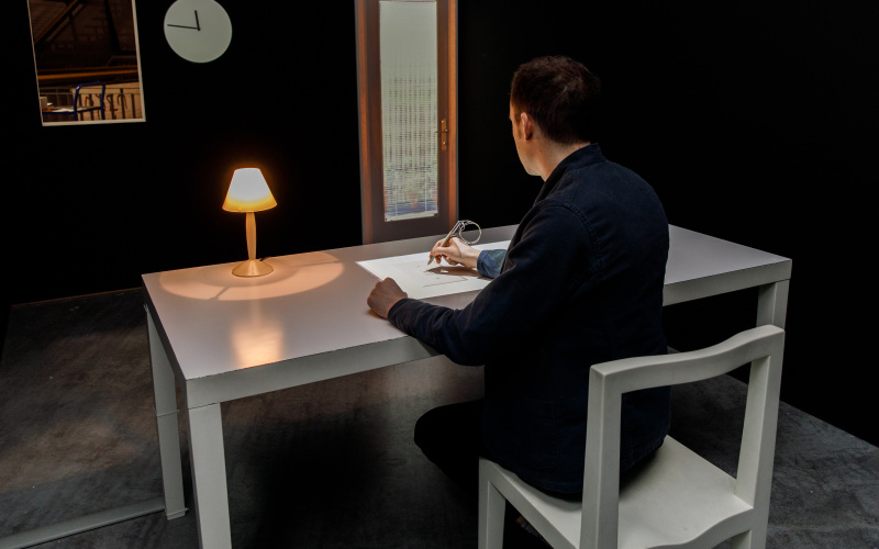 Ein Besucher am Schreibtisch der interaktiven Installation »Beyond Pages« durch Anklicken der Seiten in einem virtuellen Buch, verändert er den Installationsraum.