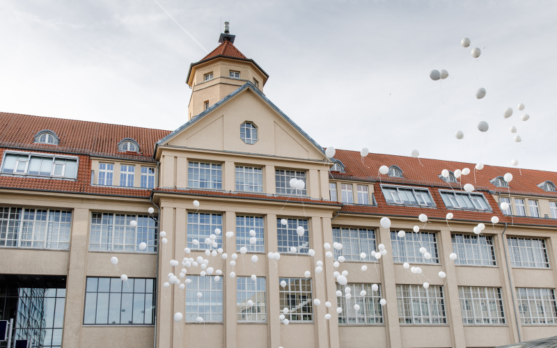 Weiße Luftballons steigen vor dem ZKM Gebäude auf.