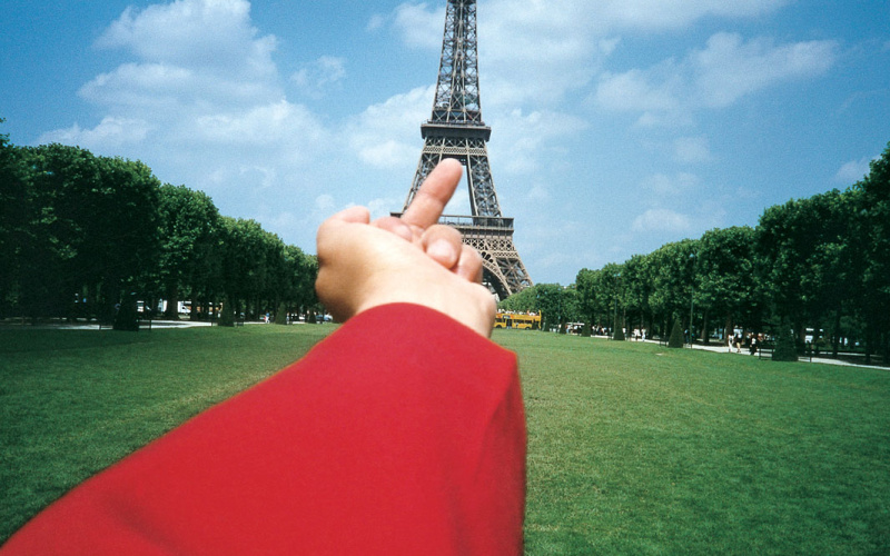 You can see an outstretched red sleeve, which points the middle finger at the Eiffel Tower.