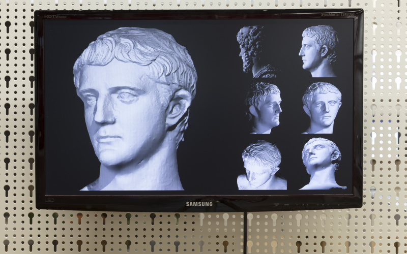 Different views of an antique statue on a flat screen monitor.