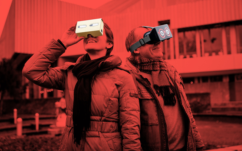  The photo shows a man and a woman, both wearing a HoloLens glasses. Above the photo is a red filter.