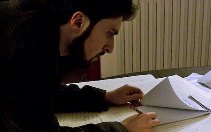 A man writes on a writing pad
