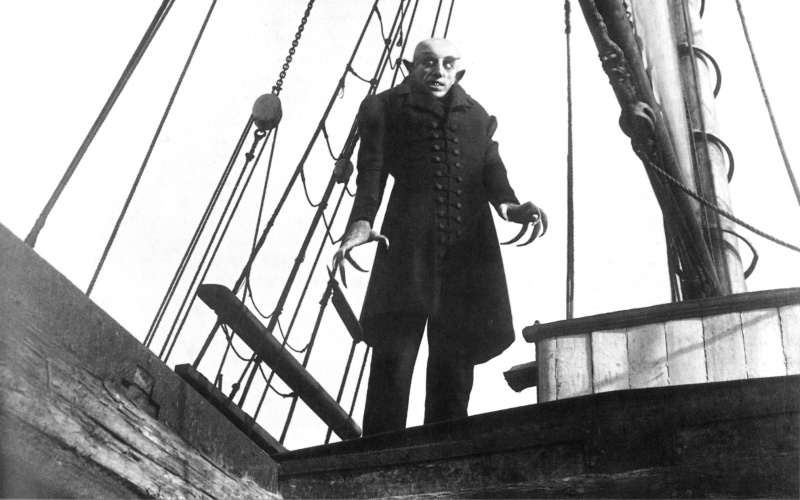 Ein Mann mit Krallenhänden steht auf einem Schiff