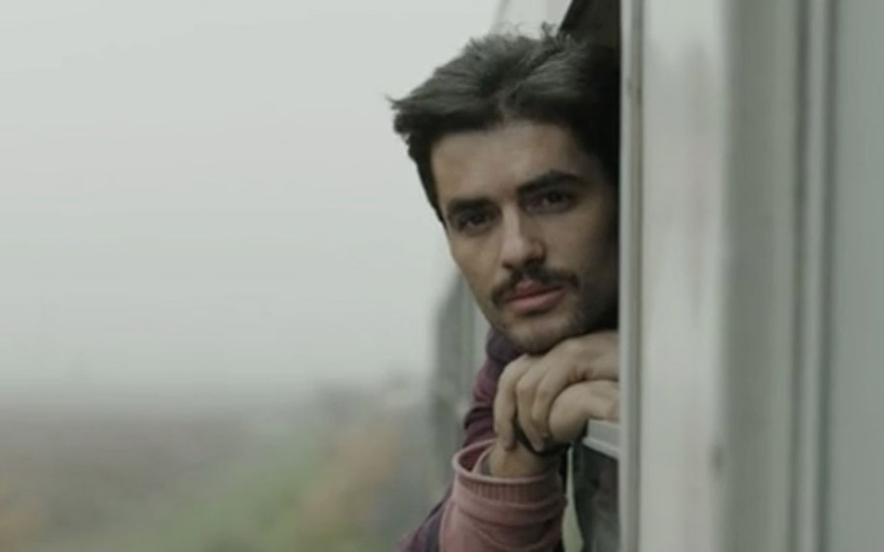 Filmstill from »Zer«: A young man looking out of a train