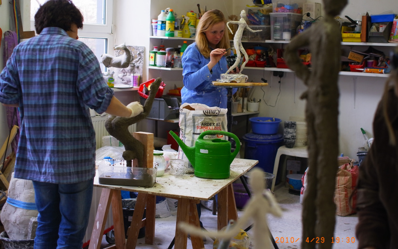 Frauen im Atelier arbeiten an schlanken Figuren aus Gips.