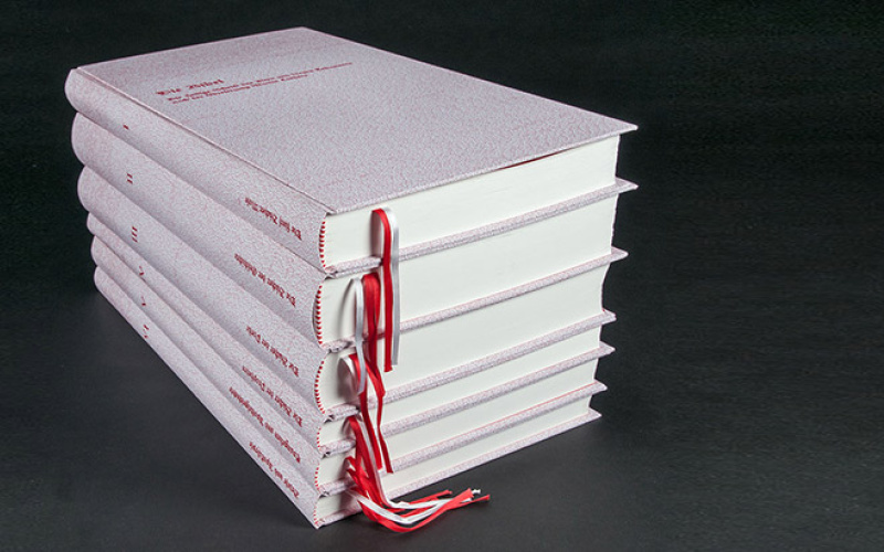 Six piled books with white book cover and red title