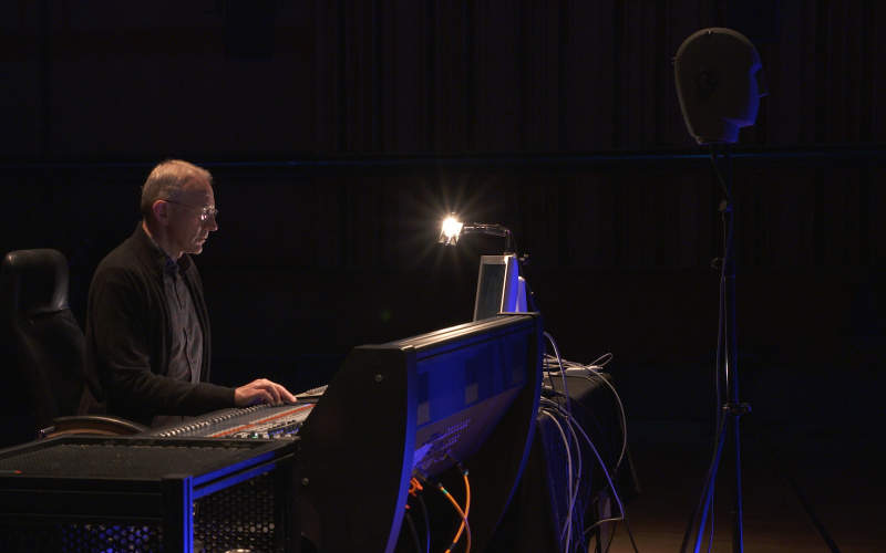 The picture shows a person playing music in front of a mixer.