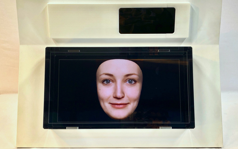 A small screen shows a female face against a blue background.