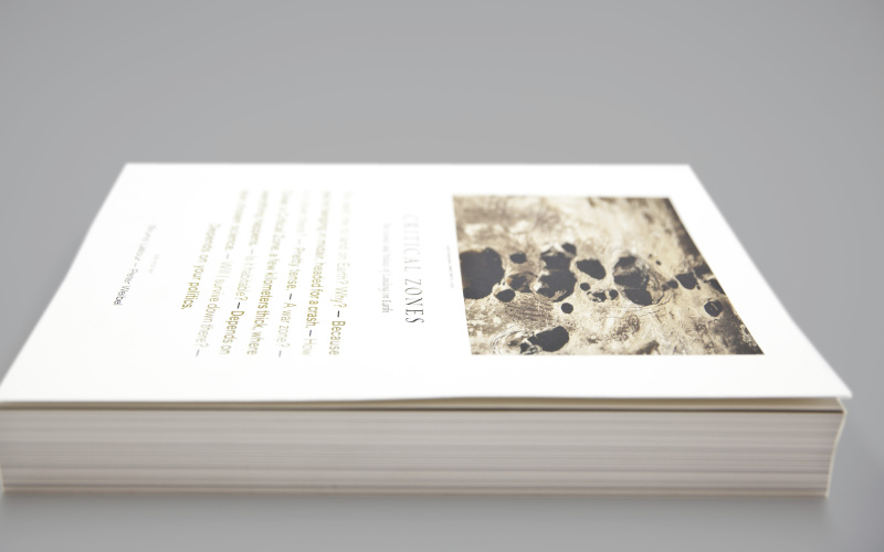 Der Katalog zur Critical Zones Ausstellung liegt zugeschlagen mit der langen Seite zum Betrachtenden. Es zeigt ein Bildcover, das vermutlich die Erdschicht zeigt, den Titel "Critical Zones" und Text