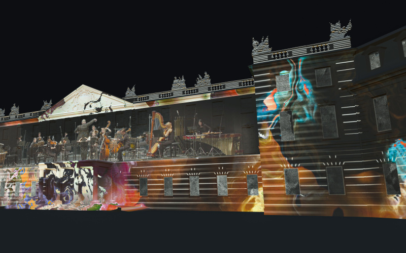 Zu sehen ist eine Visualisierung des beleuchteten Karlsruher Schlosses. Projiziert wurde ein Konzert umgeben von Graffitti-ähnlichen Abbildungen