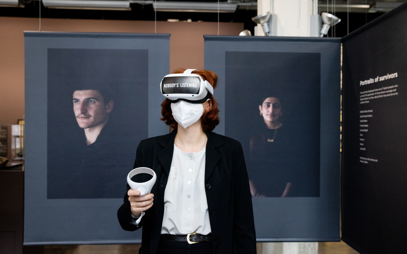 Zu sehen ist die Ko-Kuratorin Teresa Retzer, die mit VR-Brille im Ausstelungsraum steht