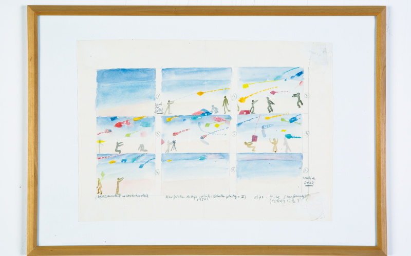 On display are six watercolor paintings on paper, arranged as a rectangle. In the pictures are several people flying kites. 