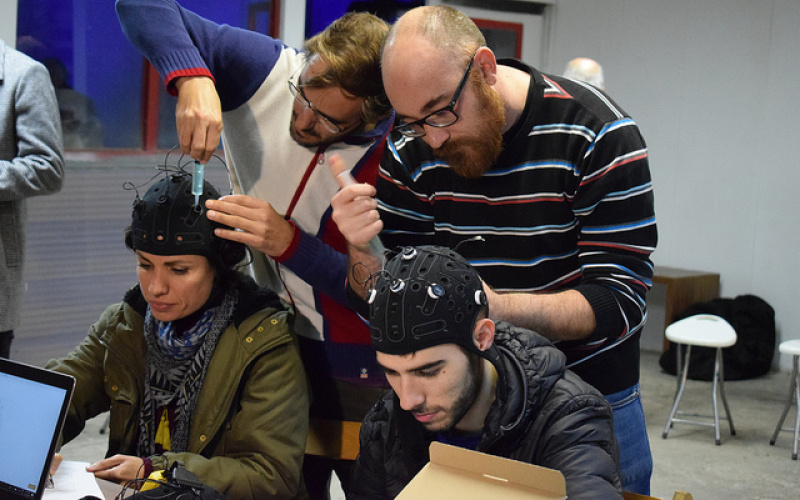 Das Bild zeigt Workshopteilnehmende beim Anbringen von Kopfsensoren.