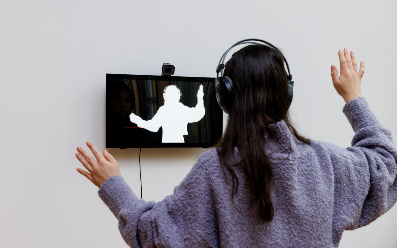 The image shows a woman whose forms are "reflected" in a screen