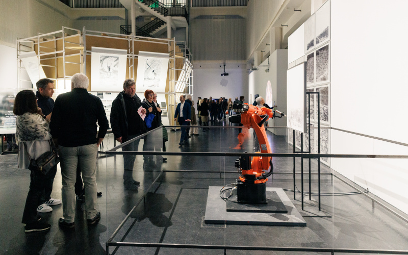 Zu sehen ist ein orangefarbener Roboter in der Ausstellungsfläche Renaissance 3.0.