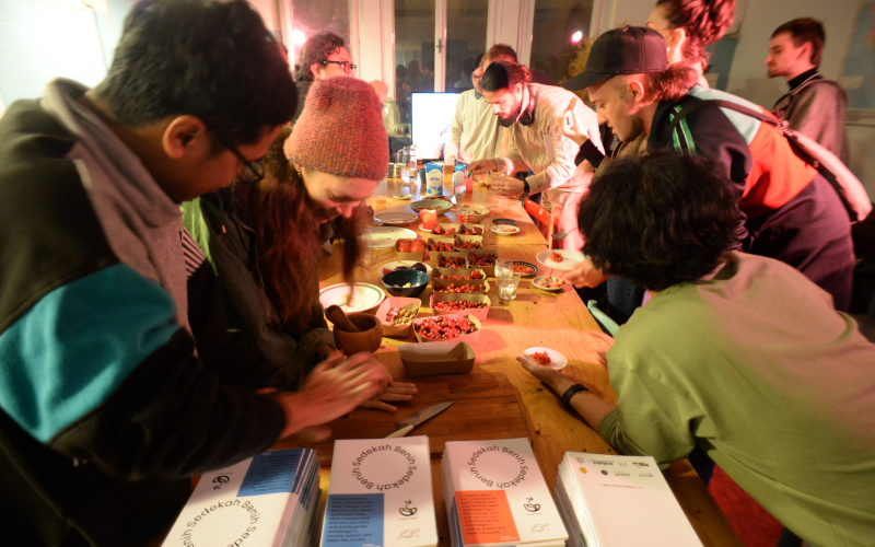 You can see several people at a table making chili paste.