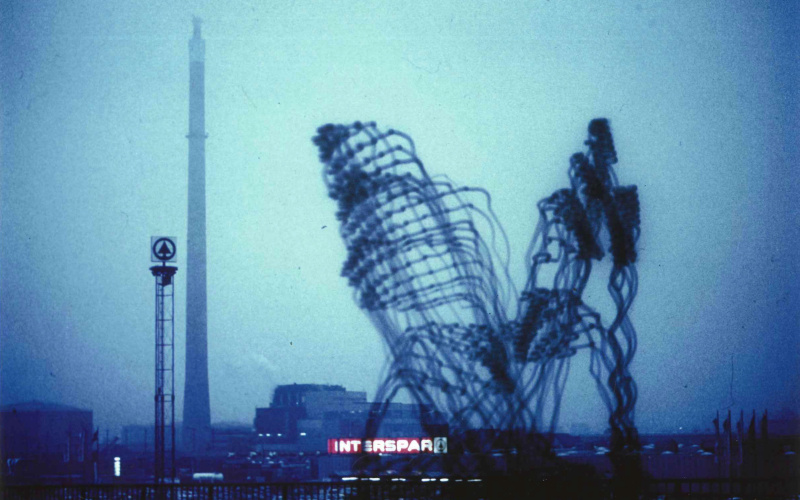 »Imaginäre Architekturen« von Otto Beckmann. Zu sehen ist eine trübe Skyline. Zwei große, figürliche Architekturen bilden das Hauptmerkmal. 