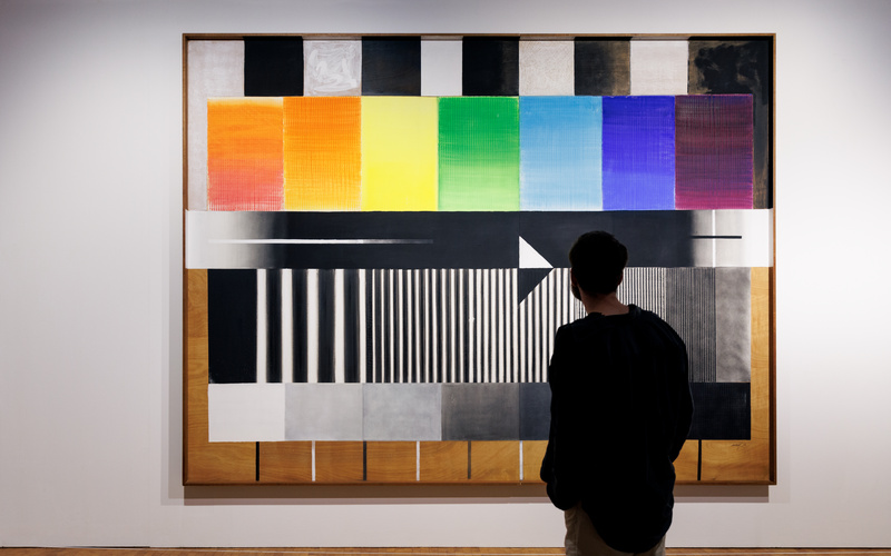 On a white wall there is a rectangle on which there are lines and rectangles in bright colours. 