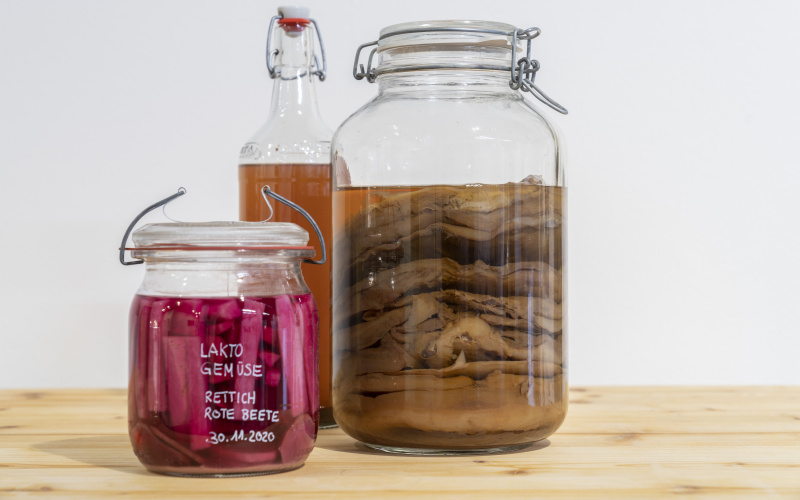 Two colorful preserving jars and a glass bottle