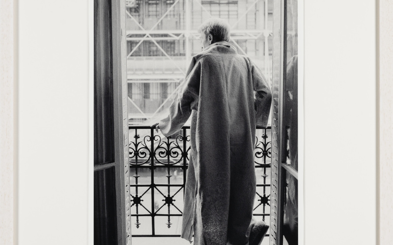 Brion posing for a series of photographs in his djellabah, standing in his window facing Centre Pompidou