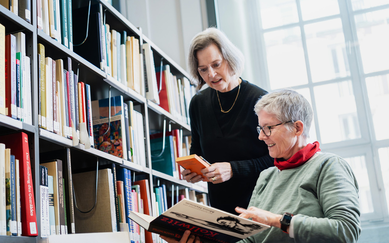 Zwei Frauen beim Einsortieren von Büchern.