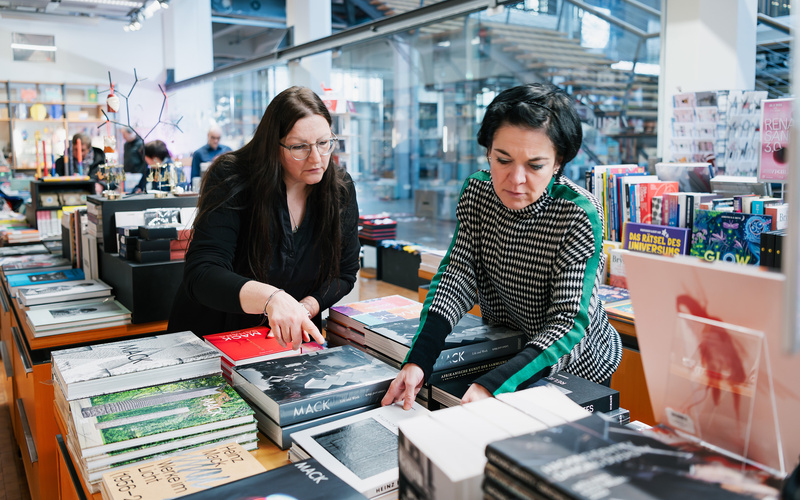 Zwei Frauen beim Richten der Bücher im ZKM Shop.