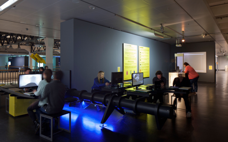 A room. Several people who play at video game consoles.