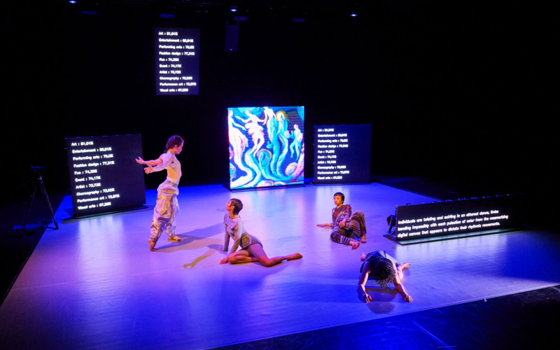 Four people can be seen on a stage. 