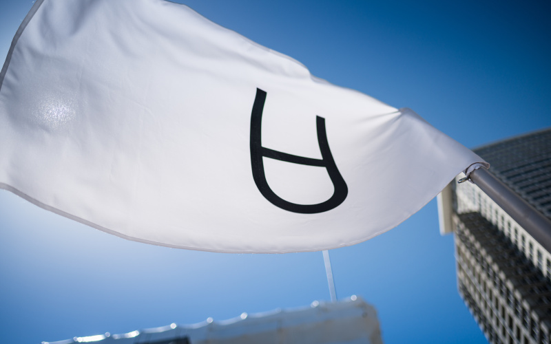 Das Symbol von Arte Útil auf einer weißen Fahne