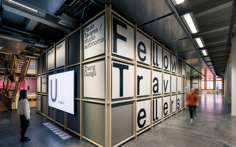 Zu sehen sind zwei Personen im Eingangsbereich der Ausstellung Fellow Travellers. 