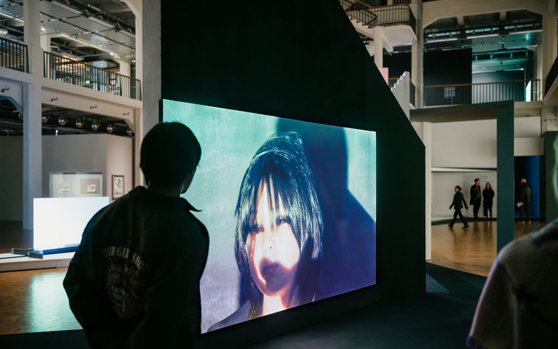 Eine große Leinwand mit einem Video in einer Ausstellung