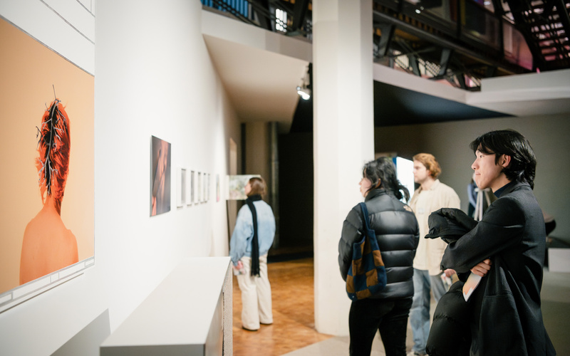 Zu sehen sind Personen, die Werke in der Ausstellung betrachten.